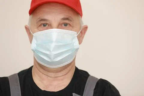 Work are done. Portrait of worker man with medical mask in red overall, black Stock Photos