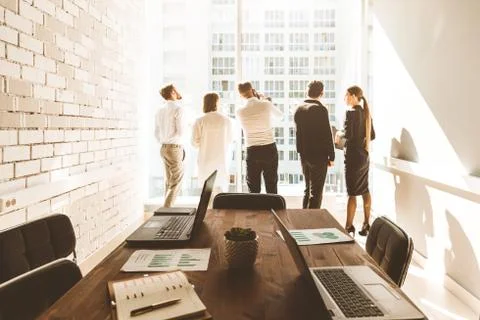 Work area on the table in the foreground. A team of young businessmen working Foto stock