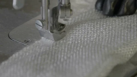 Work behind a sewing machine in a textile factory of non-horny fabric Stock Footage 126292077
