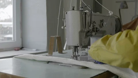 Work behind a sewing machine in a textile factory of non-horny fabric Stock Footage 126320607
