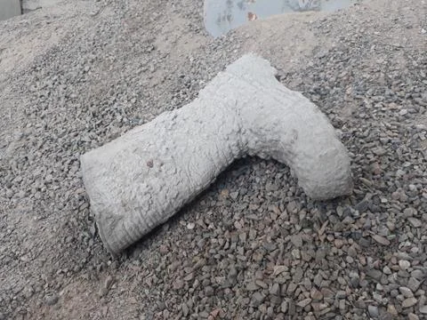 Work boots covered with cement lying on the gravel Stock Photos