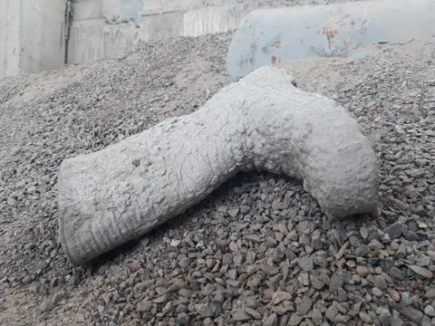 Work boots covered with cement lying on the gravel Stock Photos