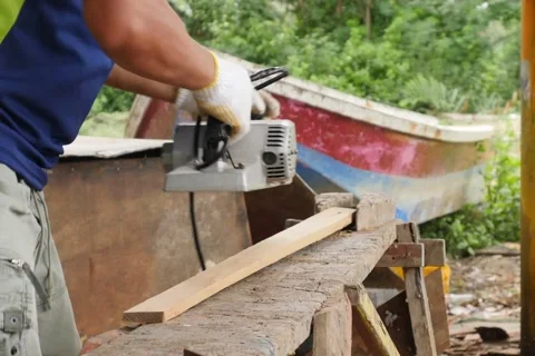 Work carpenter in the workshop. Electric Planer. Stockbeeldmateriaal 65007910