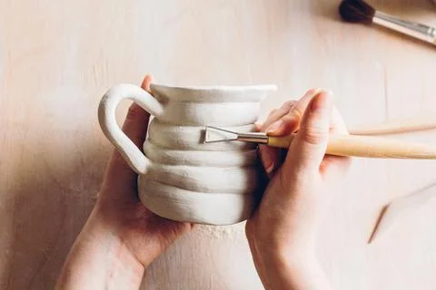 Work on a clay mug in a ceramic workshop. Stock Photos