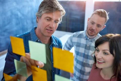 Work colleagues brainstorming with sticky notes in a modern office Foto stock