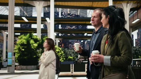 Work colleagues talking and walking inside modern bus terminal, enjoying coffee Stock Footage 340201178