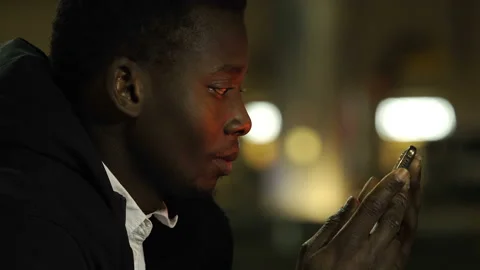 Work, communication - young black man reads work email on his smartphone  Stock Footage 147323818