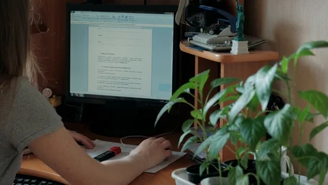 Work at the computer at home. Girl in gray sits at home and works Stock Footage 129468337