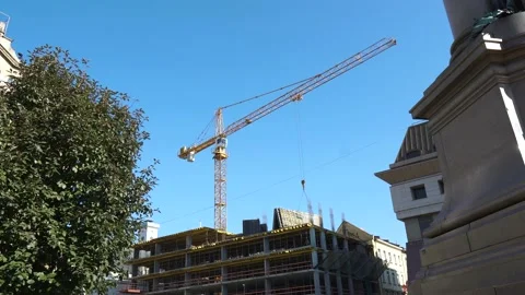 The work of a construction crane on the build of the high-rise buildings in the Stock Footage 178884929