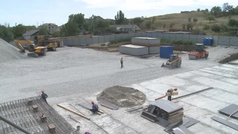 Work on the construction site. A bulldozer is passing by and workers are walking Stock Footage 104195061