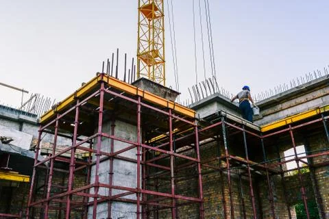 Work on the construction site. Construction of the building of yellow brick. Stock Photos