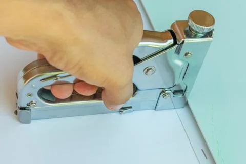 Work with a construction stapler, holding it in your hand, fasten the panels Foto stock