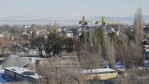 Work of cranes and cement trucks in an old factory in winter in Bishkek Stock Footage 226317898