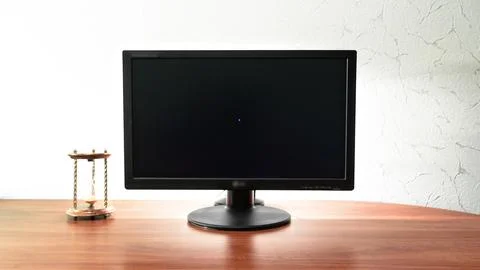 Work desk for digital job with computer, hourglass near the monitor timelap.. Stock Photos