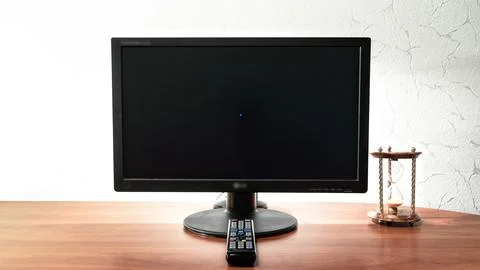 Work desk for digital job with computer, hourglass and remote control in fr.. Stock Photos