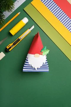 Work desk with sheets of paper, glue, ruler, and eraser on green background.  Stock Photos