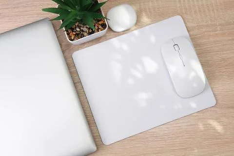 Work desk with a white mouse, notebook, and plant Stock Photos
