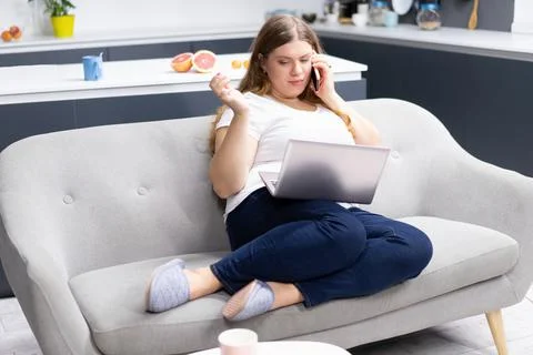 Work distantly concept. Talking on the phone with nutritionist looking at the Stock Photos