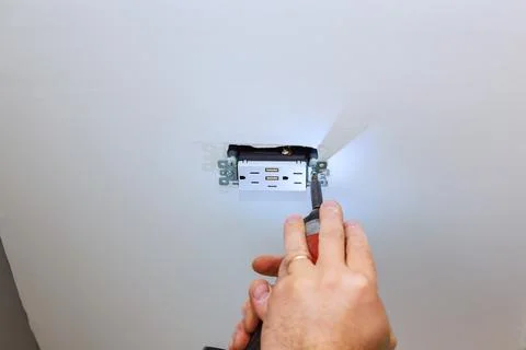 Work on electrical outlet installation in room with light tools being used Stock Photos