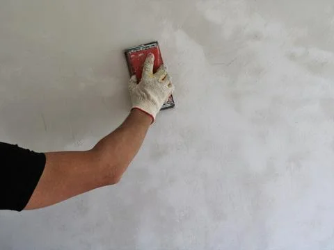 Work with an emery machine to level the surface of the wall Stock Photos