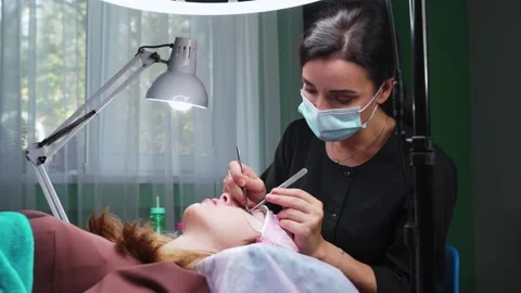 The work of an eyelash extension master. 4k Stock Footage 140712124