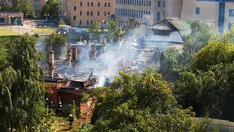 Work firefighters at putting out the burning roof of the old house Stock Footage 80021579