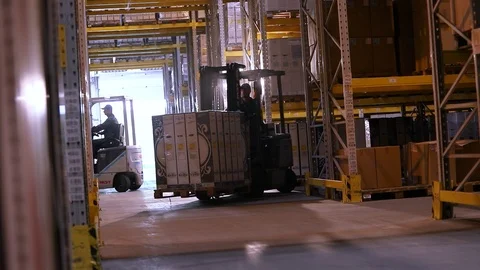 Work forklifts in the warehouse. Forklift with boxes rides between the rows in Stock Footage 109278769