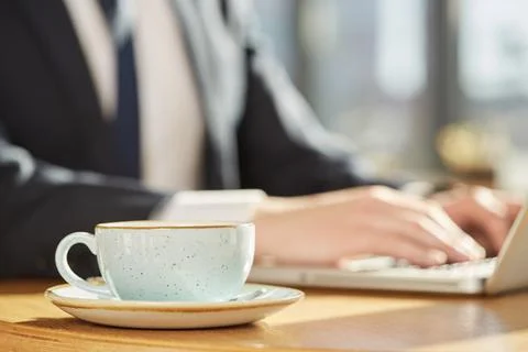 Work fuel. Selective focus on a cup on the cafe table businessman working on  Stock Photos