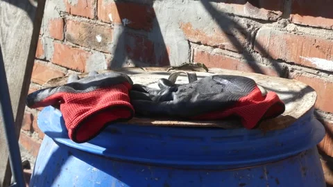 Work gloves on a blue barrel lid. Stock Footage 330541058