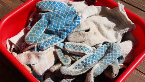 Work gloves fall into a red basin with other work gloves. Slow motion, FullHD Vídeo Stock 139049271