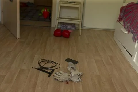 Work gloves, jump rope and boxing gloves on bedroom floor Stock Photos