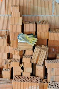 Work gloves on a stack of bricks at construcion site of a residential house 写真素材