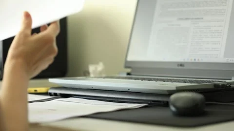 The work goes on as information is checked on laptop and hard copy, slow Stock Footage 250512438
