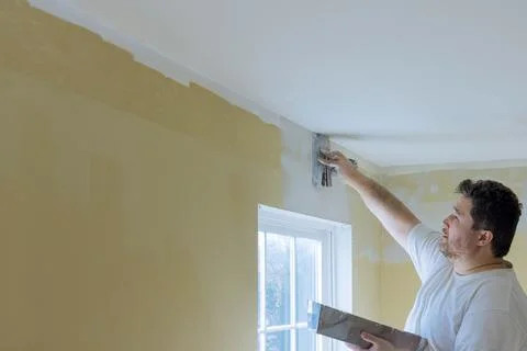 Work hand tool wall using plastering tool for finishing wall Stock Photos