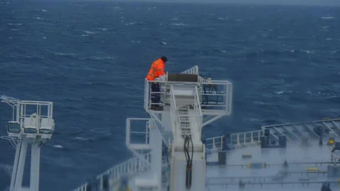 Work in hazardous conditions on a ship in a cargo crane. A man in a jean jacket Stock Footage 118472845