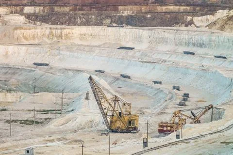 Work of heavy grapple excavators in a deep chalk quarry. Mining industry. Stock Photos
