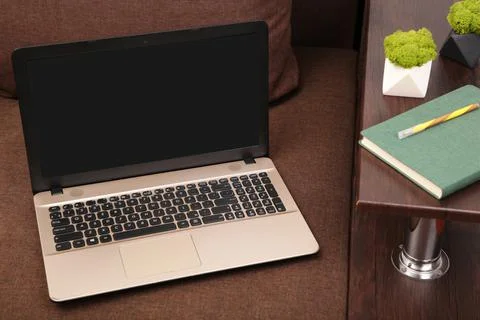 Work from home concept: laptop computer with blank white screen on gray sofa  Stock Photos