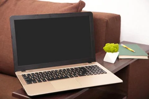 Work from home concept: laptop computer with blank black screen on brown sofa Stock Photos