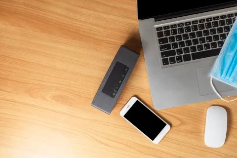 Work from home concept. Top view laptop, mouse, smartphone, speaker and face  Stock Photos