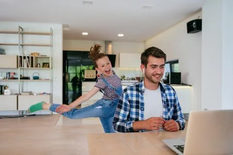 Work from home. Daughter interrupting her father while he is having a business Stock Photos