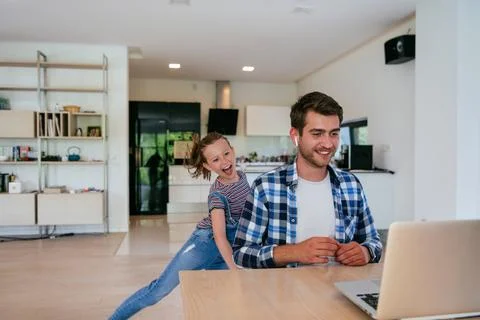 Work from home. Daughter interrupting her father while he is having a business Stock Photos