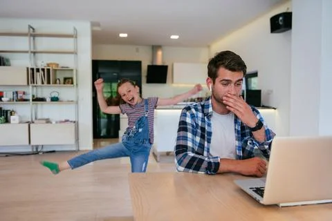 Work from home. Daughter interrupting her father while he is having a business Stock Photos