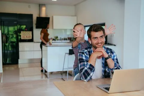 Work from home. Daughter interrupting her father while he is having a business Stock Photos