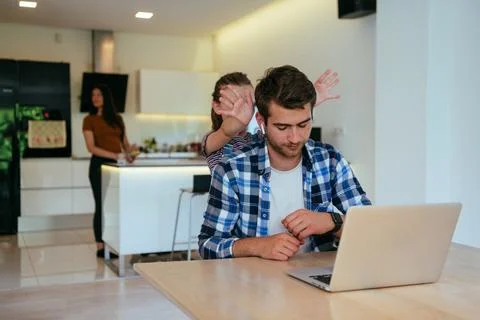 Work from home. Daughter interrupting her father while he is having a business Stock Photos