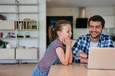 Work from home. Daughter interrupting her father while he is having a business Stock Photos