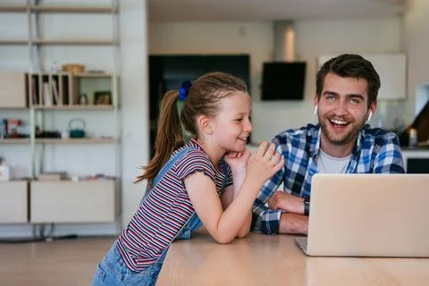 Work from home. Daughter interrupting her father while he is having a business Stock Photos