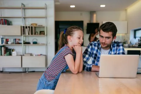 Work from home. Daughter interrupting her father while he is having a business Stock Photos