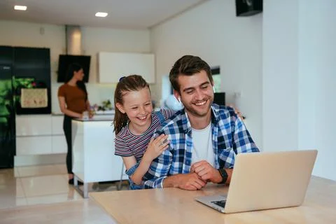 Work from home. Daughter interrupting her father while he is having a business Stock Photos