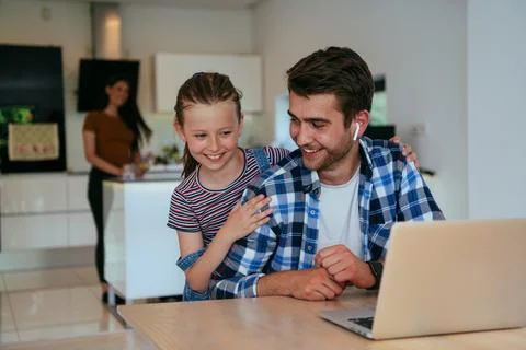 Work from home. Daughter interrupting her father while he is having a business Stock Photos