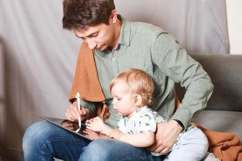 Work from home. This is a developer working on a tablet computer with childre Foto stock